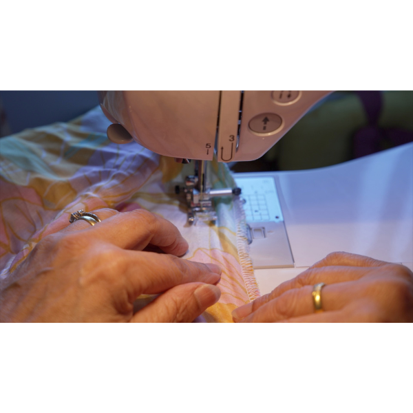 Sewing machine with hands guiding fabric under the needle